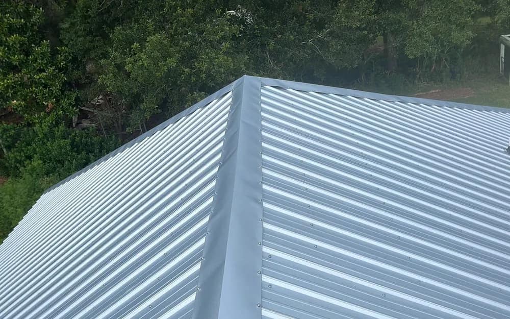 Newly installed corrugated metal roof panels meeting at the hip of a Baldwin County building